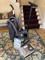 Kirby G6D vacuum with hose, attachments, user manual, and Airwick fragrance refills on carpeted floor.