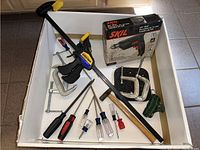 View of all items in white drawer showing Skil drill box, clamps, hammer, and screwdrivers.