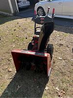 Front view of red Craftsman snowblower showing intake and auger housing, control panel, and track wheels.
