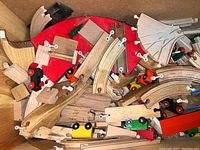 Wooden Brio toy trains and track pieces scattered showing various curved and straight track segments and train engines in multiple colors
