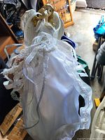 Angel figurine in white satin dress with lace and sheer ribbons, detailed wings