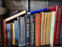 Books arranged on a shelf showing titles and spines.