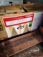 Box showing the product information and retail price for the Holiday Time 7.5 ft Pre-Lit Liberty Cashmere Quick Set Pine Christmas Tree