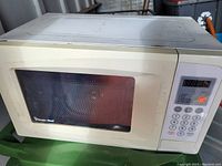 Front view of the white Magic Chef microwave, showing control panel and door with window.