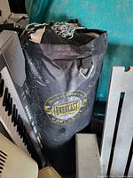 Black Everlast punching bag hanging with attached metal chains, showing branding and wear marks.