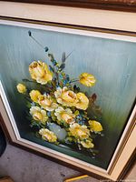 Framed oil painting of yellow flowers in a vase with a greenish background.