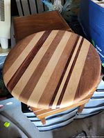 Top view showing the round wooden board with alternating wood stripes, smooth finish.