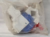 Toy in sealed plastic bag, showing wind-up siren and Ecto-1 themed design parts in white, blue and red plastic