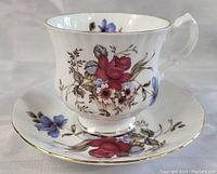 Close-up side view of the tea cup and saucer showing detailed floral pattern and gold trim.