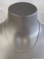 Front view of sterling silver necklace on display bust, showing fine chain with a shiny finish.