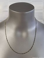 Front view of sterling silver necklace on a dark mannequin bust, showing the full length of the chain with a shiny finish.