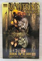Front cover of Wolverine Origins hardcover graphic novel showing Wolverine crouching next to a wolf with title and credits.