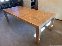 Angled front-left view of dining table showing top surface and legs
