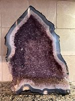 Front view of entire amethyst geode showing purple crystal interior and agate banding