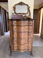 Front view of tall oak dresser showing five drawers, cabriole legs, scalloped apron and mirror