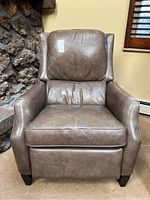 Front-facing view of brown leather recliner chair showing overall shape and condition