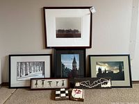 Six framed art and decor pieces including black and white landscape photos, city architectural photos, and small decor items.