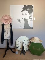 Full lot view showing pink hats, large canvas print, dress form on garment stand, clock face, Eiffel Tower decor, and Harrods hat box