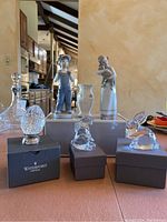View of all six pieces including Lladro figurines, Waterford crystal rabbits and egg shaped piece, and Belleek vase