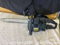 Angle showing full length of the chainsaw on fabric surface