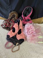 Full view of dog jackets and pink tutu on textured surface