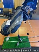Photo of blue and black Lark Golf bag with stand, standing on floor