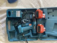 Photo showing the Makita cordless drill and two batteries in teal blue plastic case