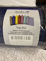 Close-up photo of product label showing brand Zensation, product type yoga mat, premium studio-grade, in multiple colors with blue highlighted, packaging label visible.