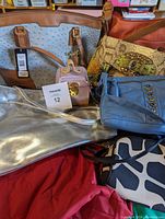 Five handbags arranged together showing the variety including Guess, snakeskin print, metallic silver, blue, and orange bags.