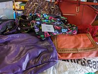 Overview photo showing six handbags stacked on top of each other in various colors and materials.