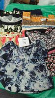Five assorted ladies plus size XL tops laid out, displaying various colorful patterns and designs.