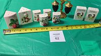 Photo of assortment of vintage ceramic spice shakers and containers with measuring tape showing approximate sizes.