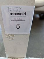 Close-up of measurement handwritten on a white wooden frame reading 42 x 34 inches