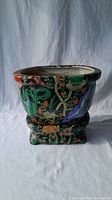 Front view of the hand painted planter showing the botanical design and base.