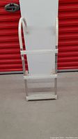 Front view of the white 3-foot pool or boat ladder with three steps flat metal steps and tubular handrails.