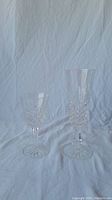 Two Waterford crystal glasses, one champagne flute and one sherry glass, on white background