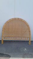 Front view of rattan wicker headboard showing full arched design and pattern.