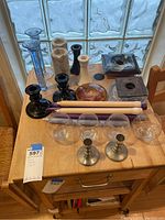 Full view of the assorted candle holders and taper candles on a wooden surface.