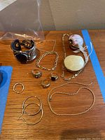 Full lot displayed on wooden surface showing cuff, chains, beads, hoops and rings
