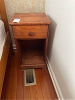 Wooden nightstand closed drawer top view, showing the overall condition and a price tag.