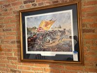 Framed Civil War battle scene showing soldiers with a large yellow and red battle flag, set against a brick wall.