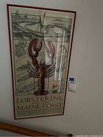 Full view of framed lobster wall art poster with lobster and coastal scenes.