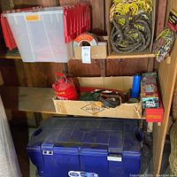 Shelf view with gasoline tank, fire extinguisher box, ropes, and storage tote visible