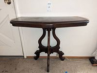Full view of the Eastlake style wood side console table showing the tabletop and carved base.