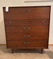 Front view of tallboy dresser showing five drawers, metal pulls, and round knobs