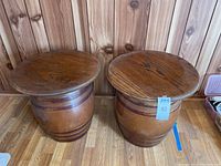 Pair of ceramic barrel side tables with wood tops viewed from above and front.