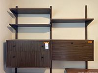 Full view of wall-mounted cabinetry with shelves showing two cabinets below and three adjustable shelves above, mounted on vertical supports.