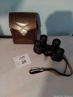 Wetzlar binoculars placed next to a closed brown leather carrying case.