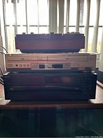 Photo showing three stacked devices: silver Sony DVD/VHS combo player on top, black Nikko CD changer below.