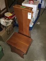 Side view showing wooden valet stand and storage under seat with scuffs visible